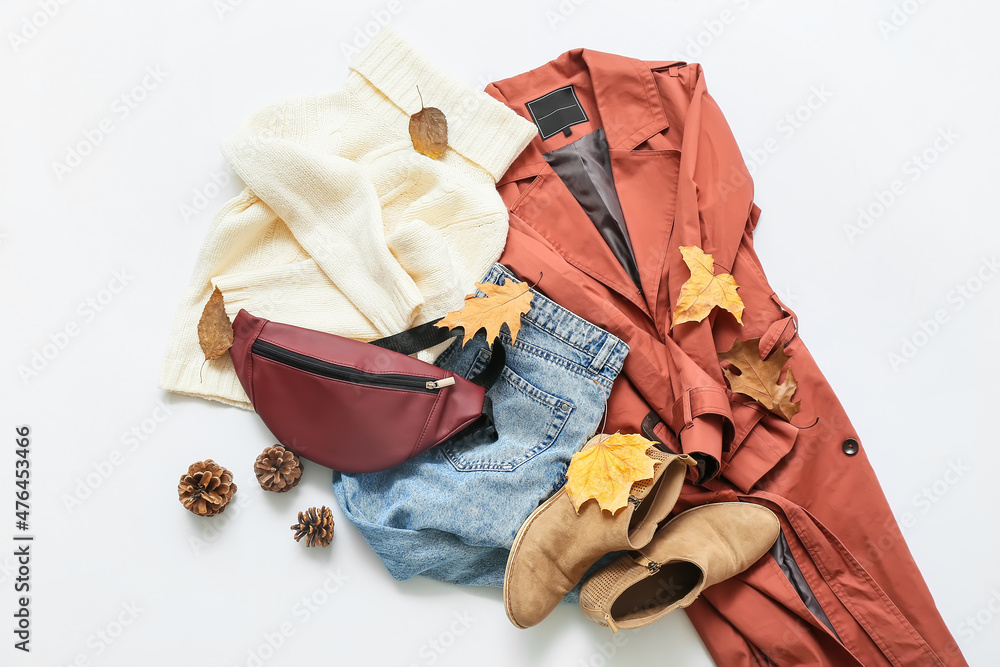 时尚的女性外套、毛衣、牛仔裤、包包和浅色背景的秋季装饰