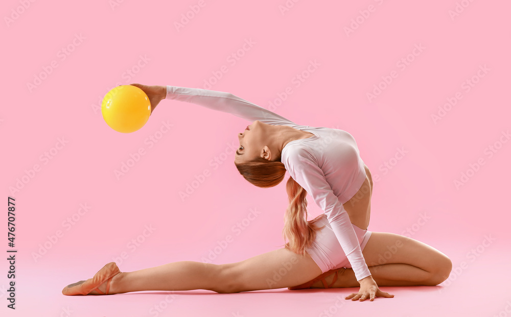漂亮的年轻女子用彩球做体操