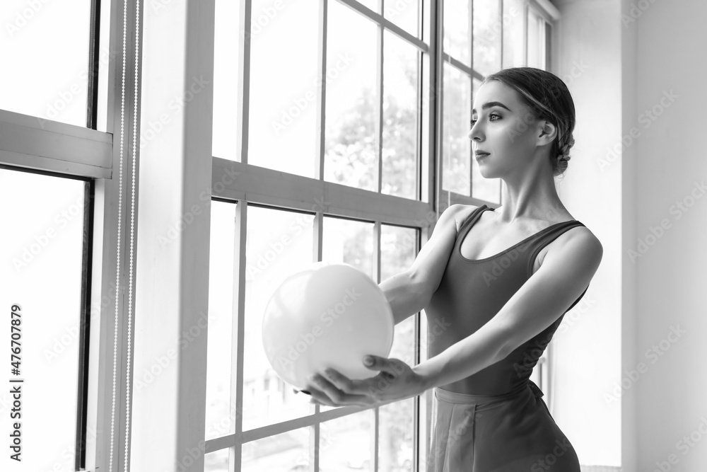 美丽的年轻体操运动员在健身房带球的黑白肖像