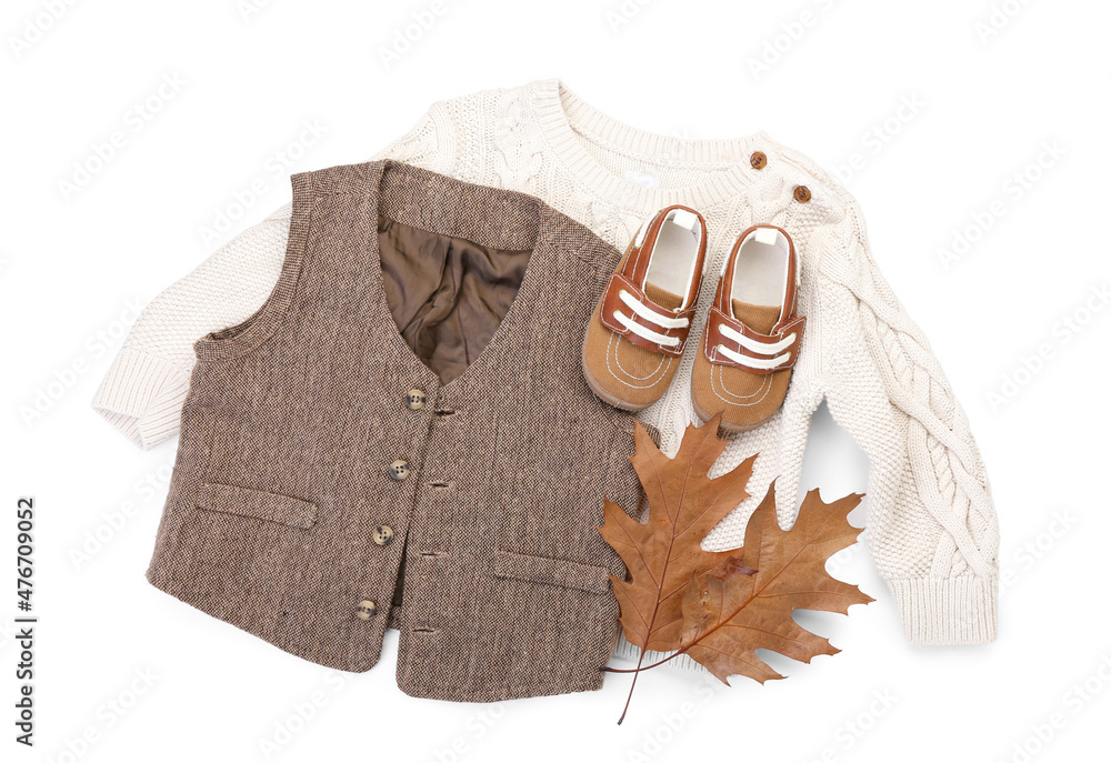 白色背景下的婴儿衣服、鞋子和秋叶