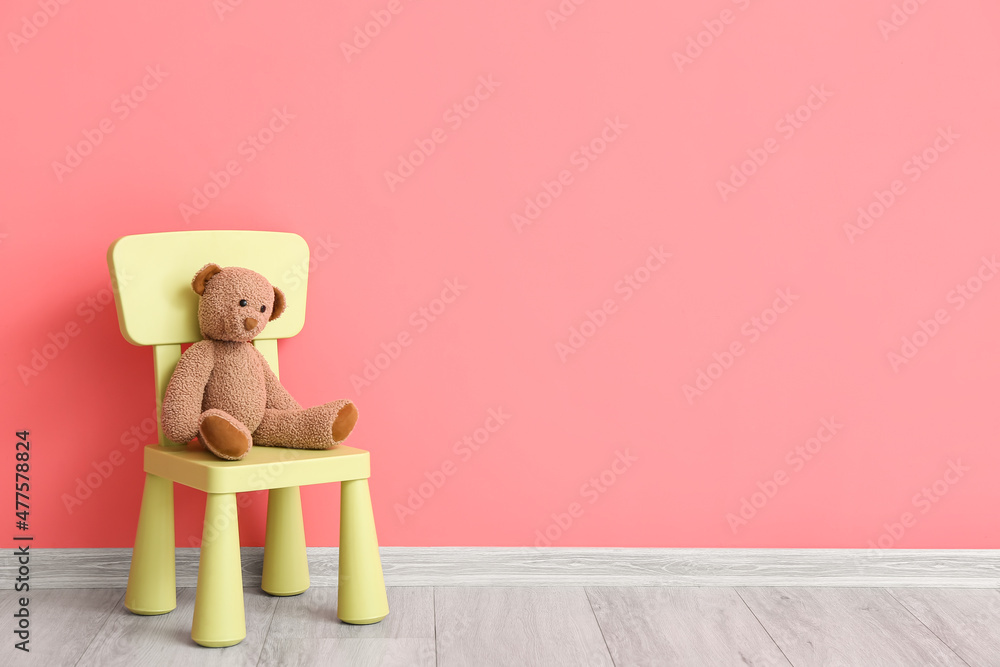 彩色墙上有可爱的熊玩具的儿童椅