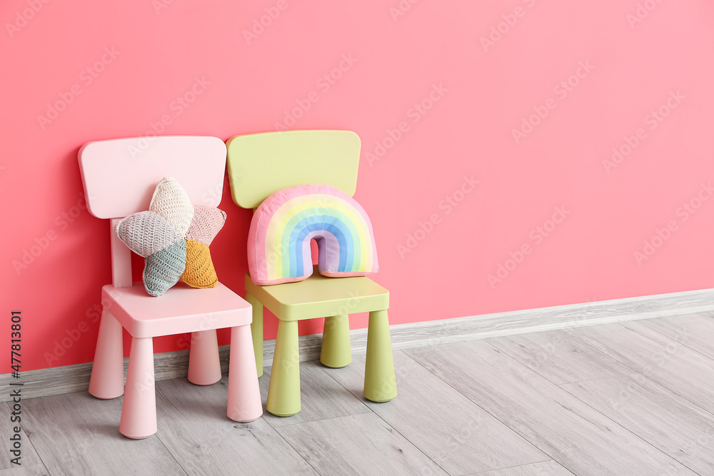 靠近彩色墙的带玩具的儿童座椅