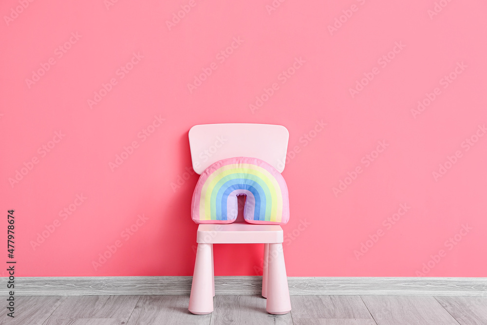 彩色墙附近带玩具的儿童座椅