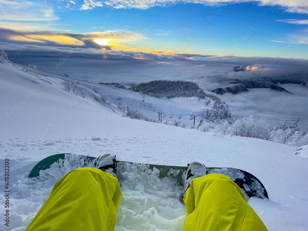 POV：在滑雪板之旅中，坐在新鲜的雪中看日落