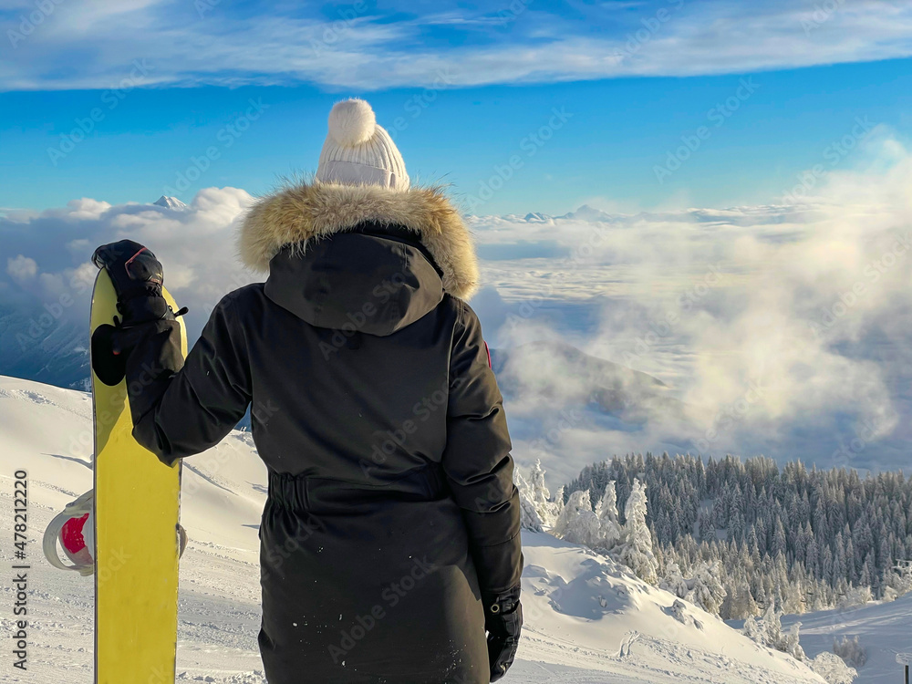 CLOSE UP: Female snowboarder observes alpine landscape before riding off piste