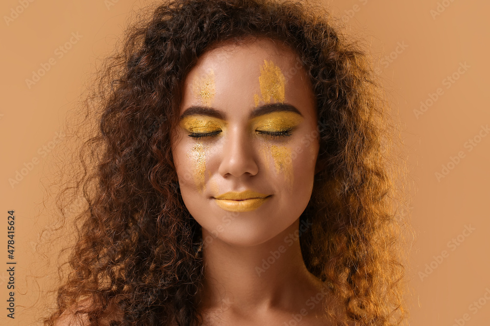 美丽的年轻女子，在彩色背景下脸上涂着黄色的油漆