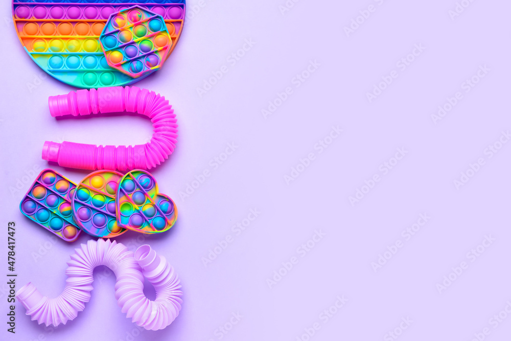 紫色背景的彩色Pop Tubes和Pop-it fidget玩具