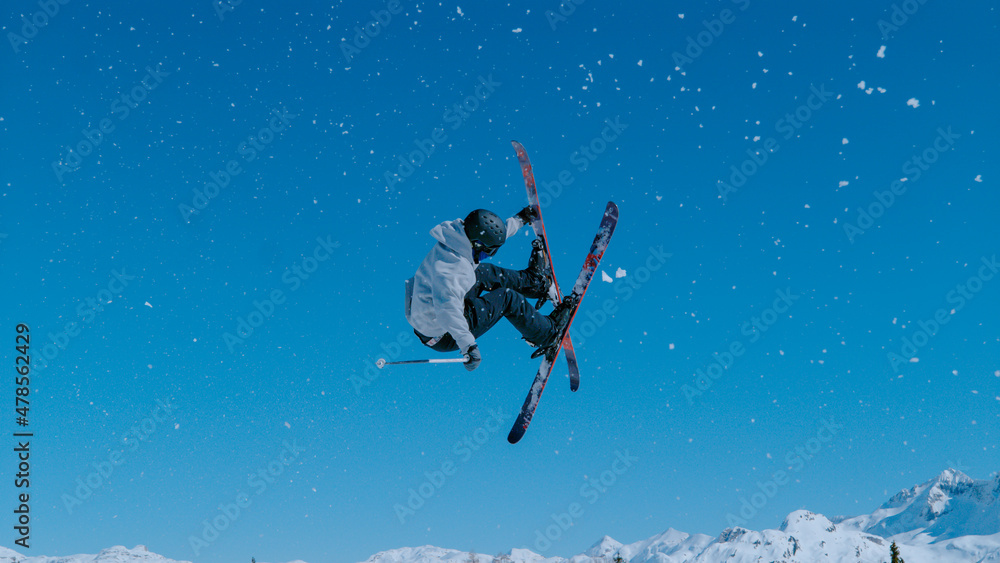 专业的自由式滑雪运动员骑上一个踢球者，做了一个惊险的旋转动作。