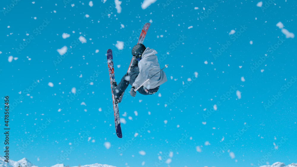 一名男子自由式滑雪运动员脱下踢球者并进行360度抓握的动作镜头
