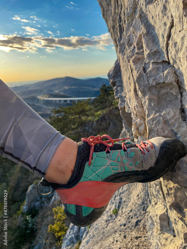 垂直：女性登山鞋在踏上岩石立足点时获得抓地力。