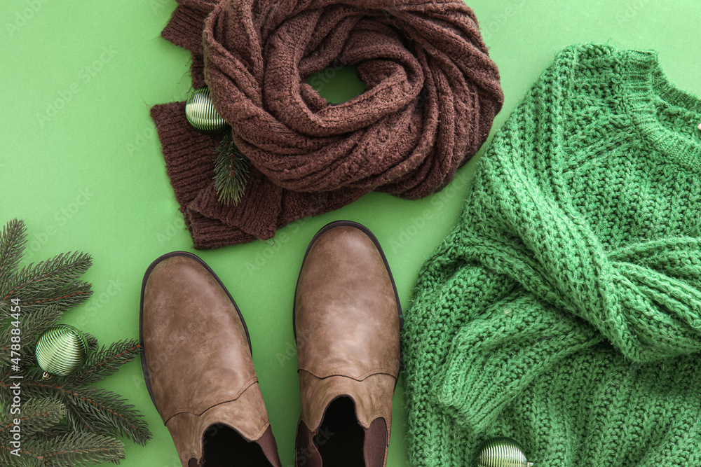 绿色背景的针织毛衣、围巾、鞋子和圣诞装饰，特写