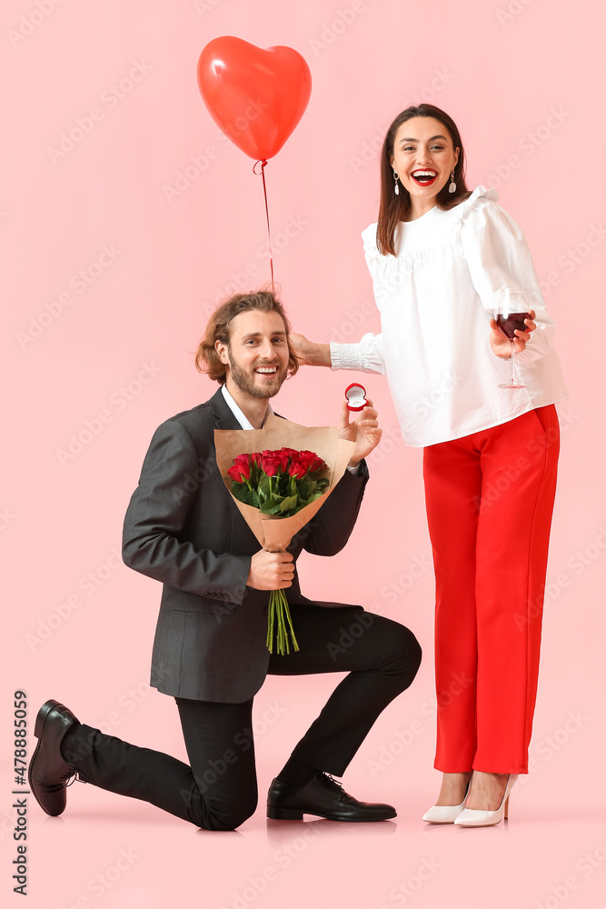 年轻男子在彩色背景下向女友求婚。情人节庆祝活动