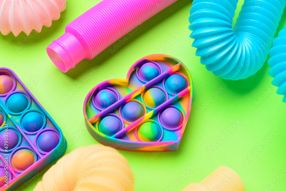彩色流行管和绿色背景上的流行玩具
