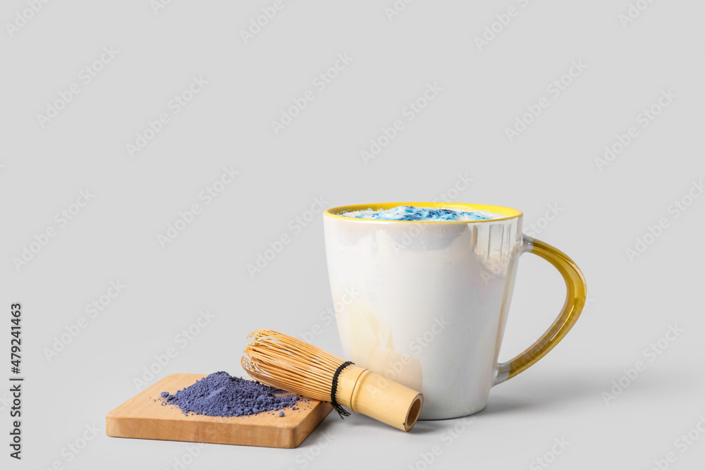 一杯美味的蓝色抹茶拿铁，白底分离有追逐和粉末