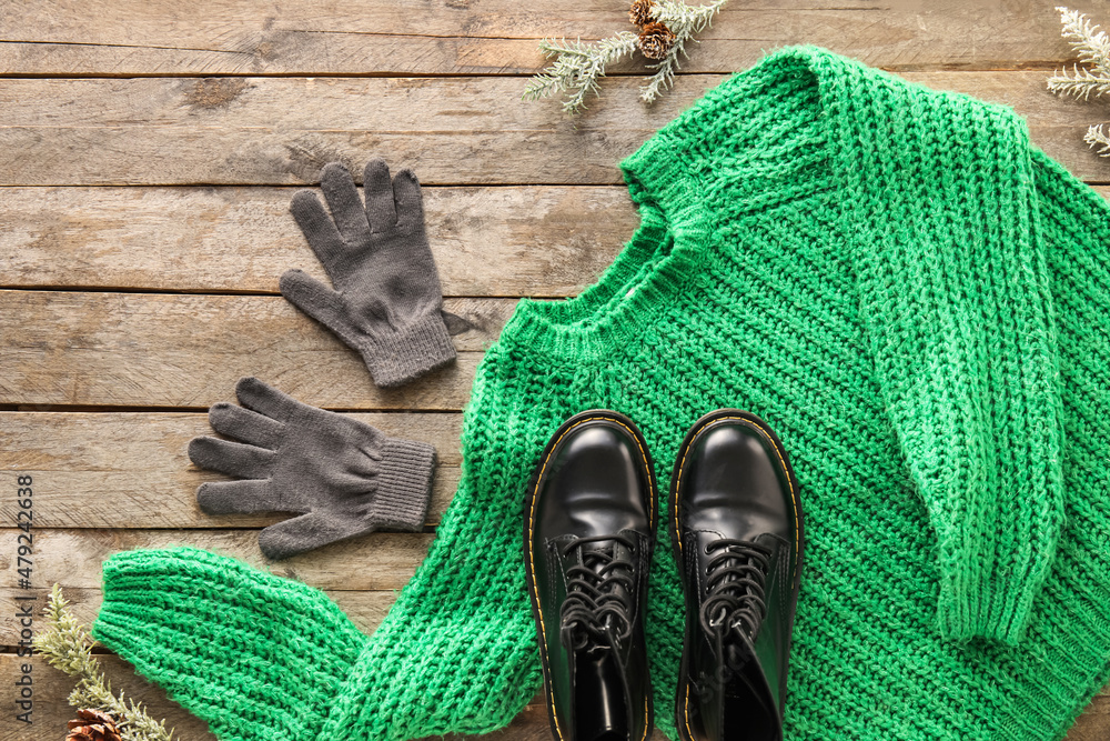 木制背景上的针织毛衣、手套、鞋子和冷杉树枝