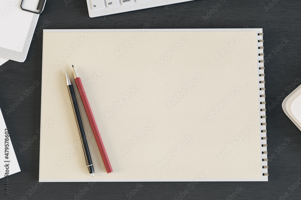 深色木制桌面上带键盘和铅笔的空白螺旋记事本的俯视图。绘图，工作包