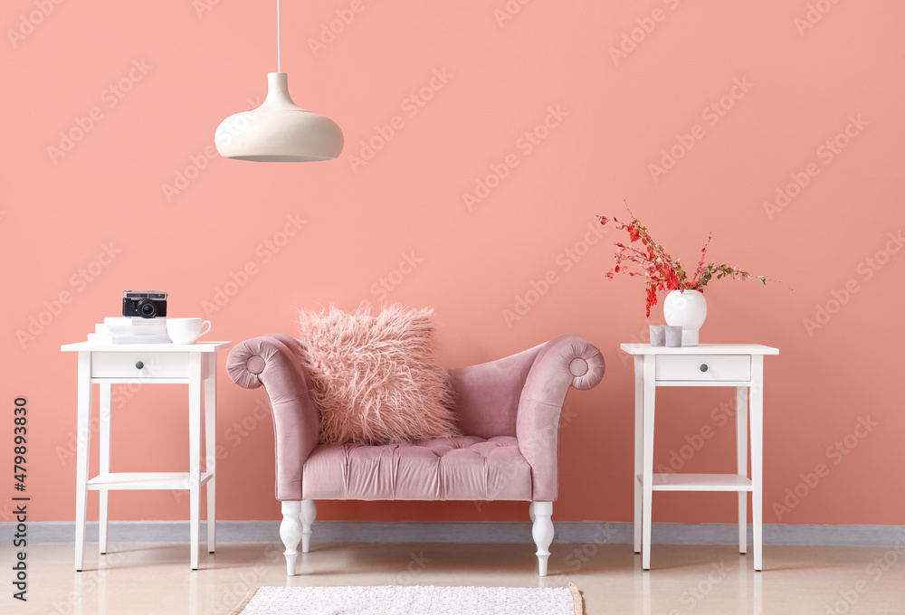 时尚舒适的扶手椅，房间粉色墙壁附近有桌子