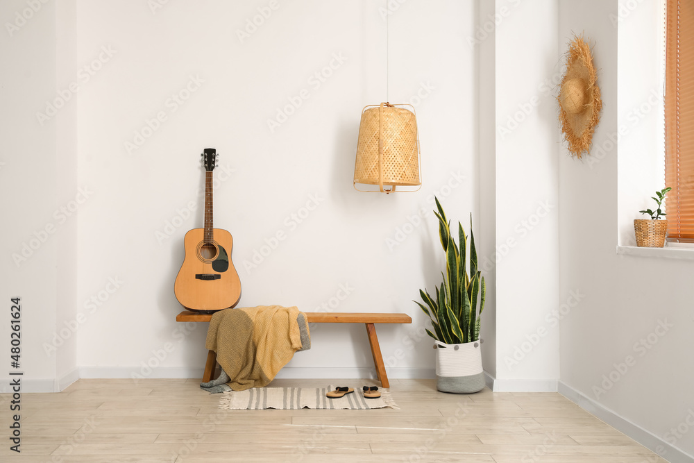 带木长椅、吉他和室内植物的灯光室内