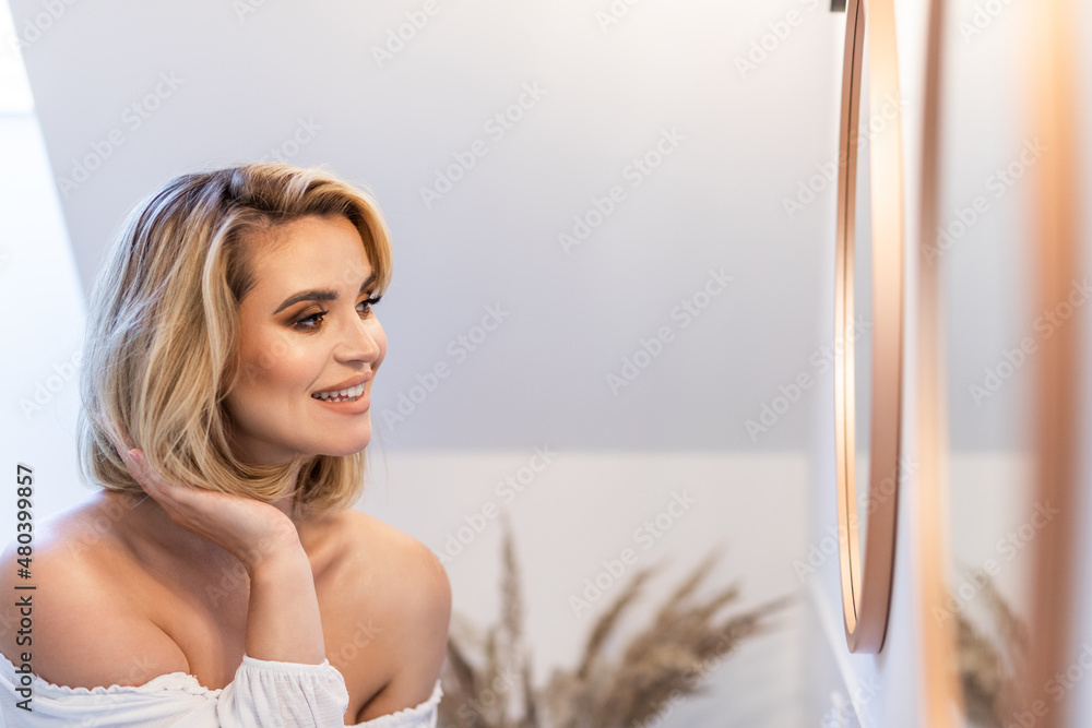 检查头发年轻女子在浴室里照镜子