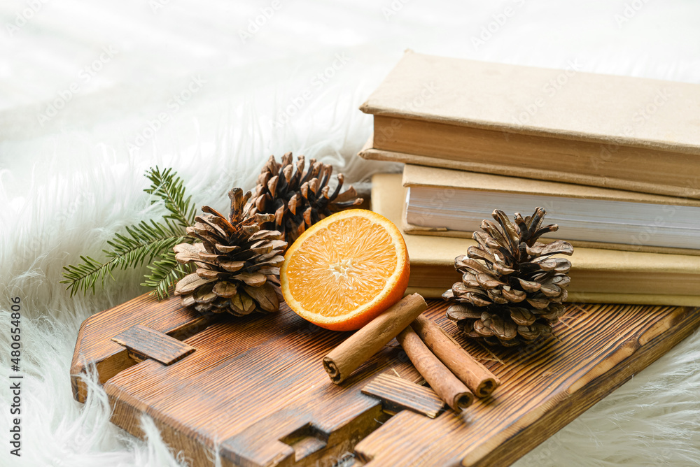 软地毯上有切割的橙色、松果和书籍的木板