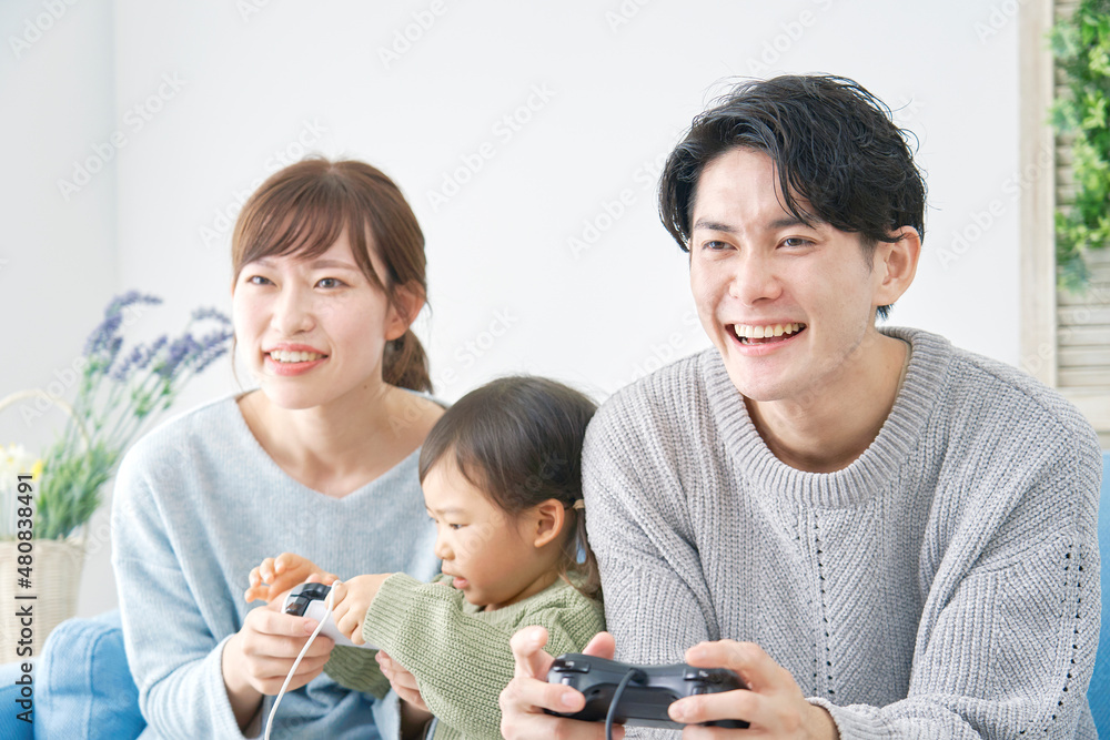 テレビゲームで遊ぶ家族