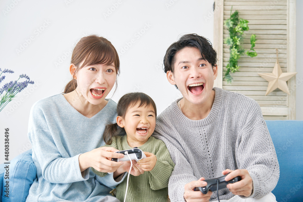 テレビゲームで遊ぶ家族