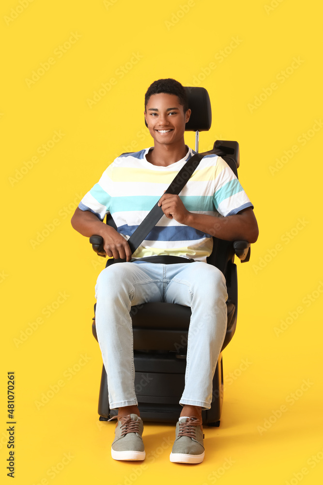 非裔美国人坐在彩色背景的汽车座椅上