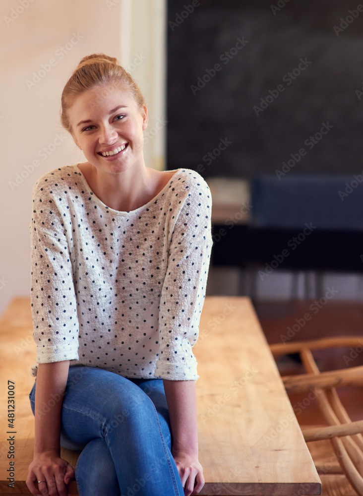 在家过得很开心。一张年轻女子坐在厨房桌子上的照片。