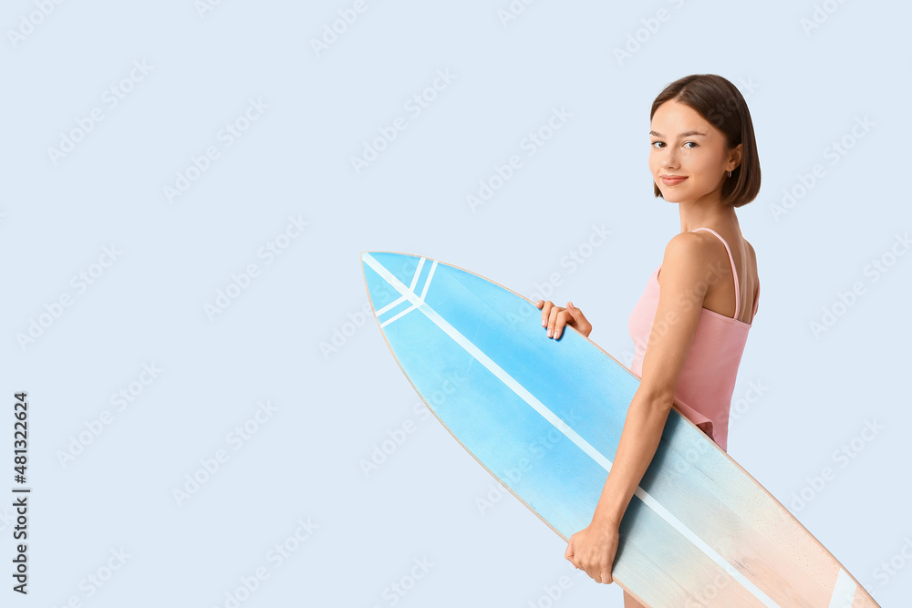 美丽的年轻女子，灯光背景下有冲浪板