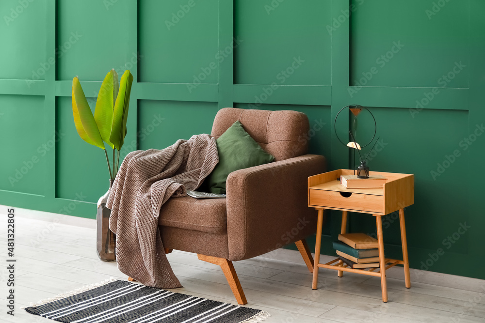 房间里靠近彩色墙壁的格子和桌子的舒适扶手椅