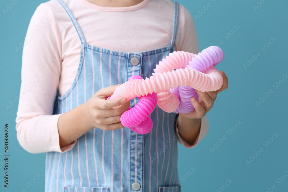 Little girl with Pop Tubes on blue background, closeup