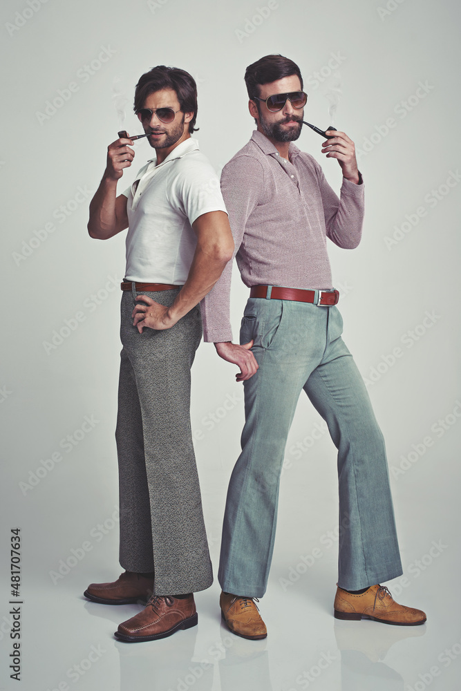 We know were groovy. Studio shot of two men standing together while wearing retro 70s wear and stri
