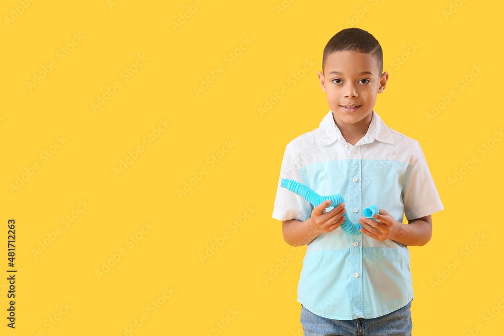 黄色背景下带蓝色Pop Tube的非洲裔美国小男孩