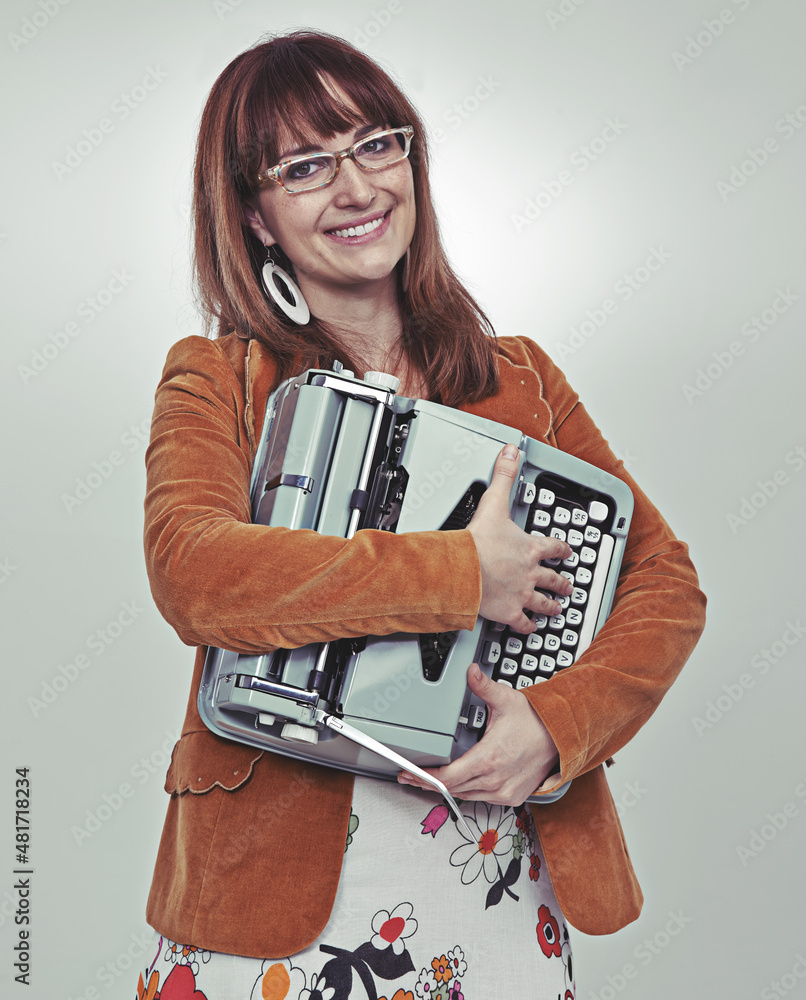 Ill be a published author soon. Studio shot of a bookish young woman in retro clothing hugging her 
