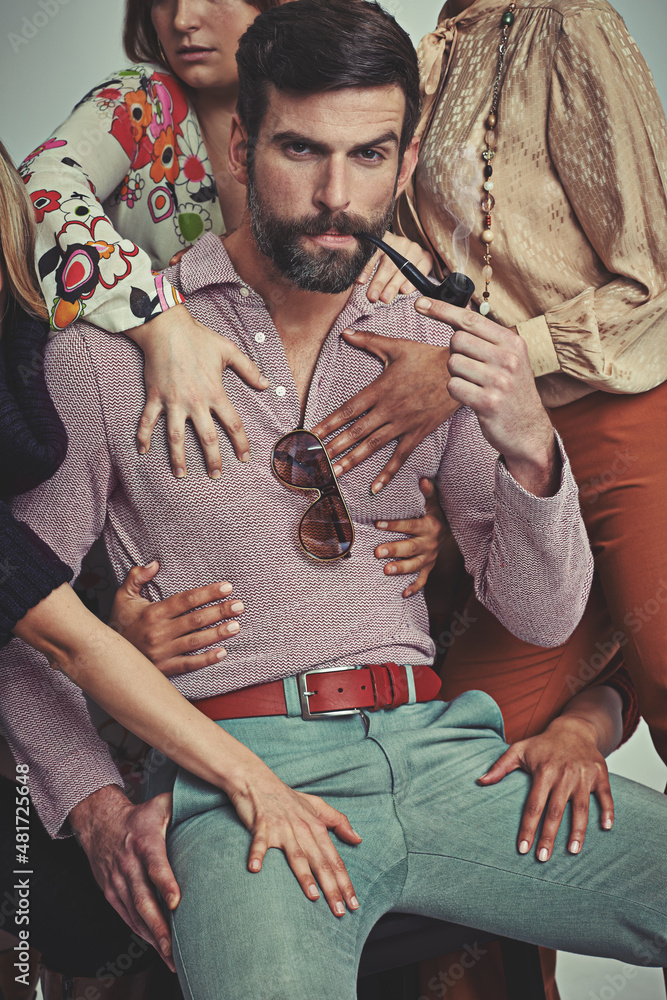 Im a ladies man, for sure. Studio shot of an attractive man in retro 70s wear being touched by wome