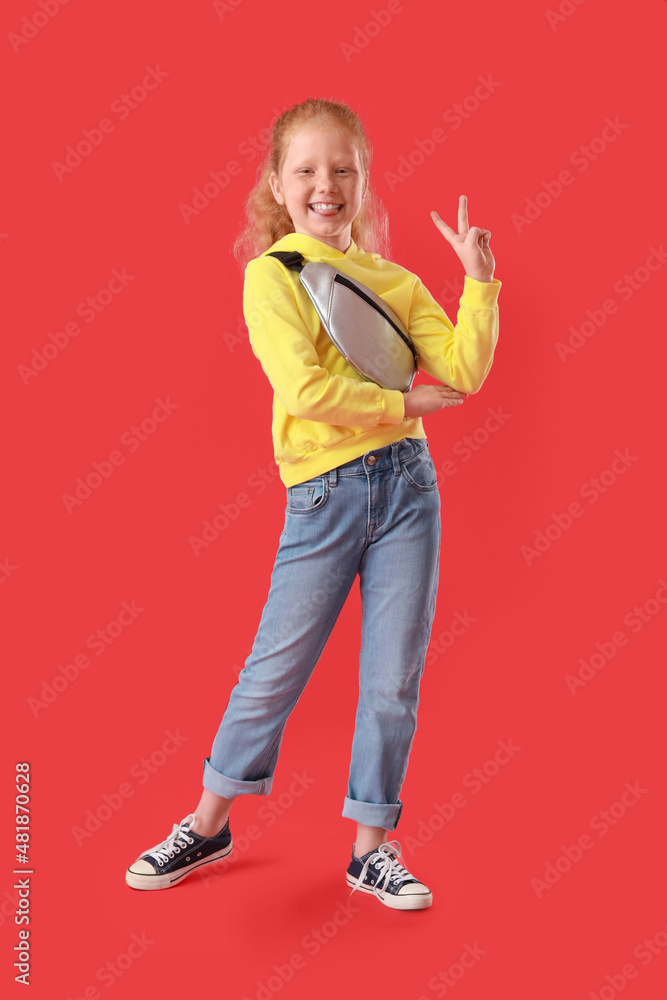 Little girl with bum bag on red background