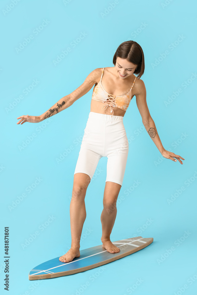 Beautiful young woman with surfboard on color background
