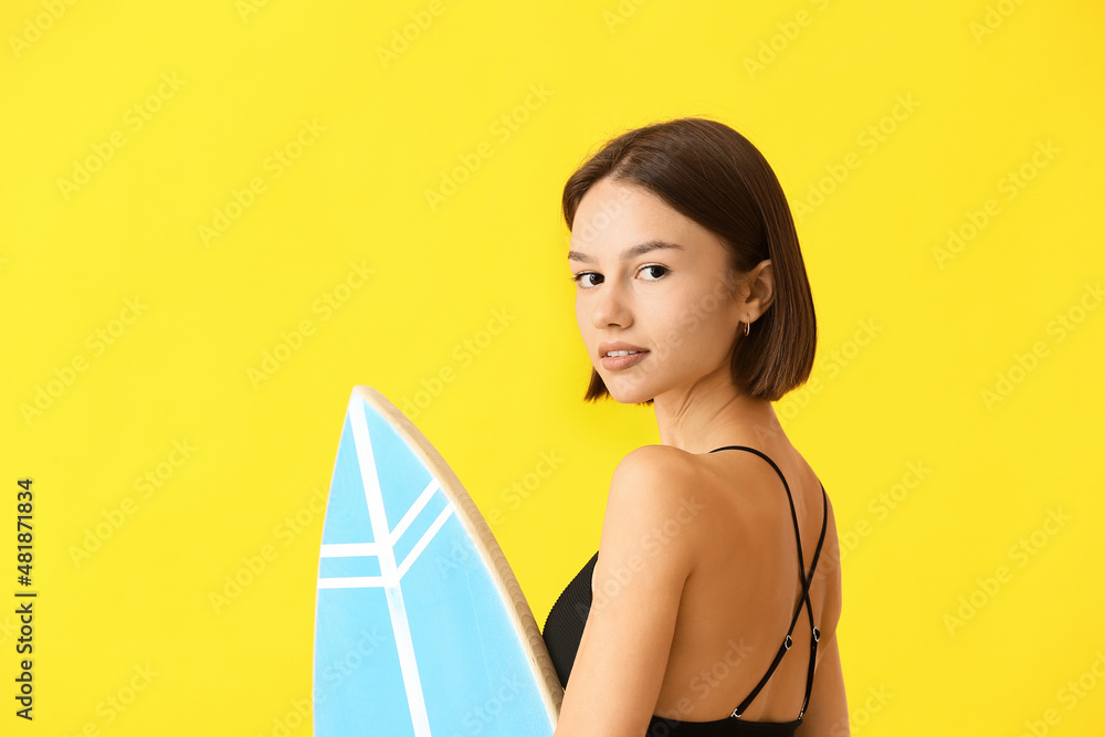 美丽的年轻女子，彩色背景上有冲浪板