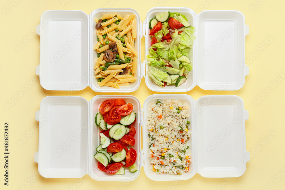 Food delivery containers with tasty meals on color background