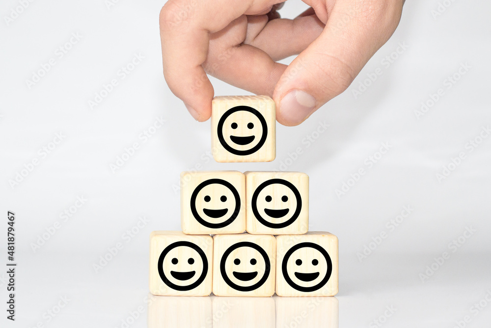 木头立方体上的笑脸。乐观的人或人内心的感觉和服务评级，满意度