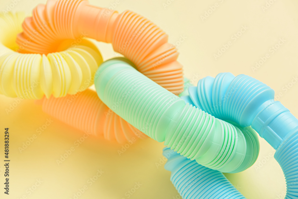 米色背景下不同颜色的流行管，特写