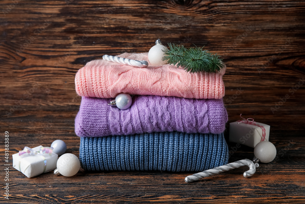时尚的婴儿毛衣和木制背景的圣诞装饰
