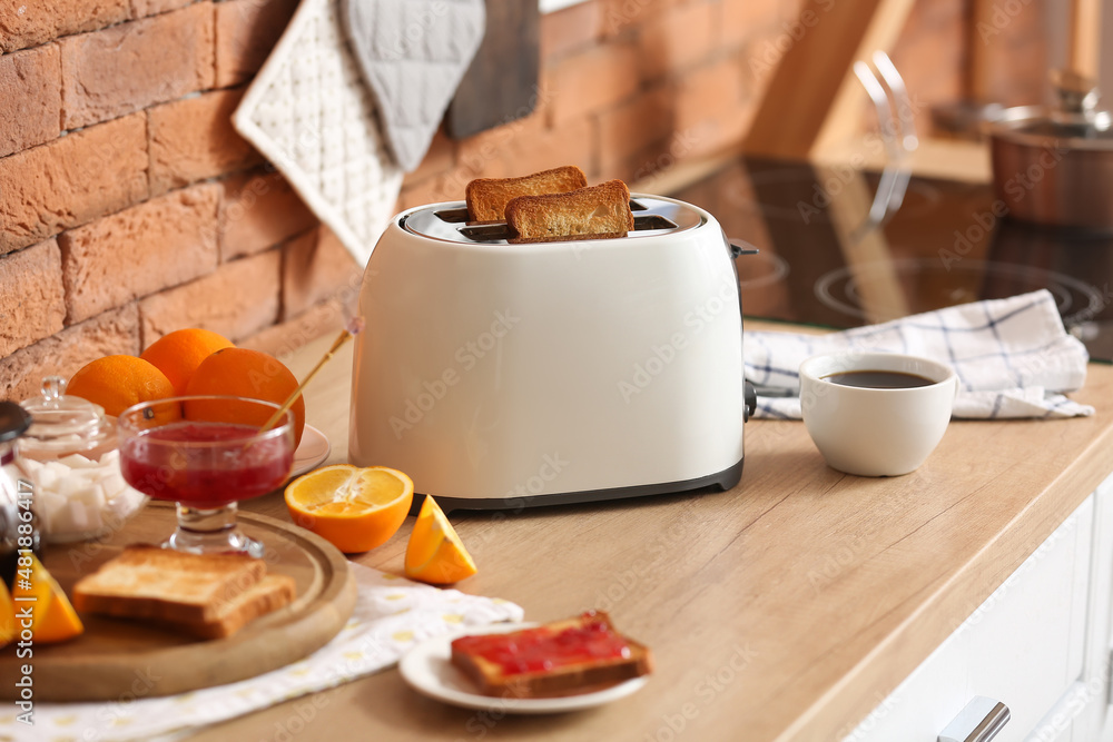 砖墙附近的柜台上有美味早餐的白色烤面包机
