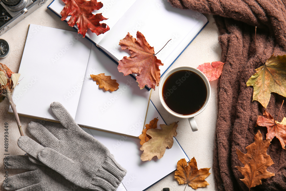 空白书籍、温暖的手套、一杯咖啡和浅背景的秋季装饰