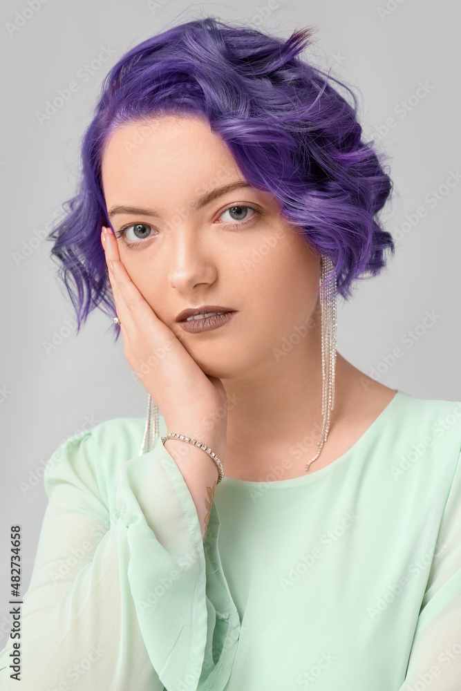 美丽的年轻女子，浅色背景下有紫罗兰色的头发。非常危险——2022年的颜色
