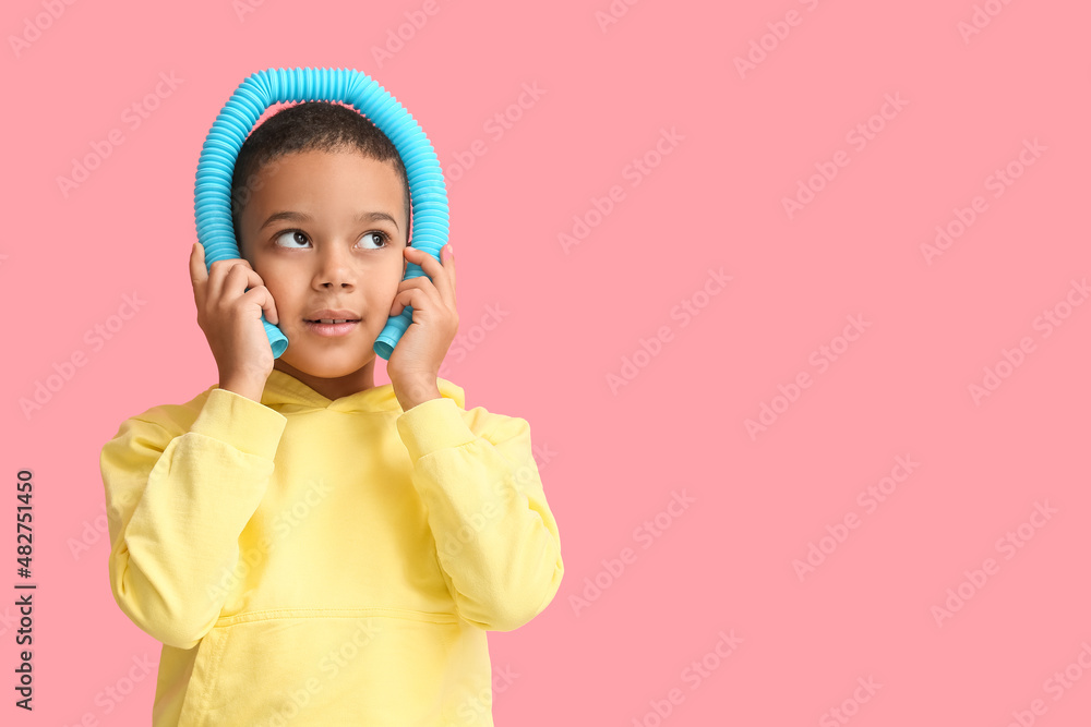 粉色背景下带蓝色Pop Tube的非洲裔美国小男孩