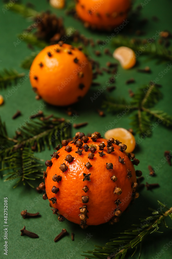 手工制作的圣诞装饰，由绿色背景下的橘子、丁香和冷杉枝制成，c