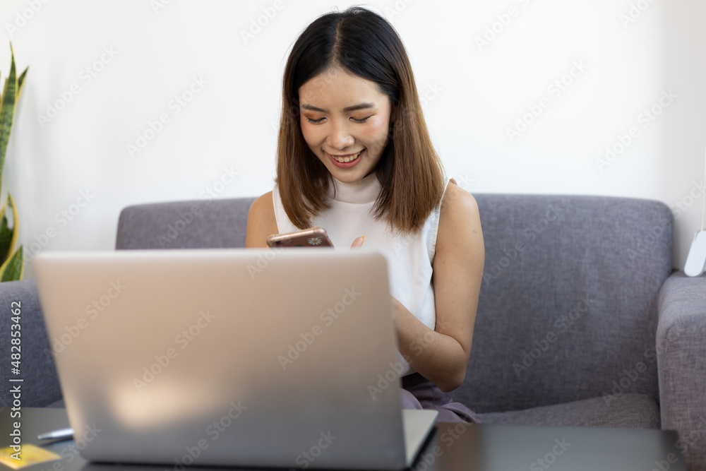 亚洲女性在家使用笔记本电脑。在家工作和网上购物的概念。