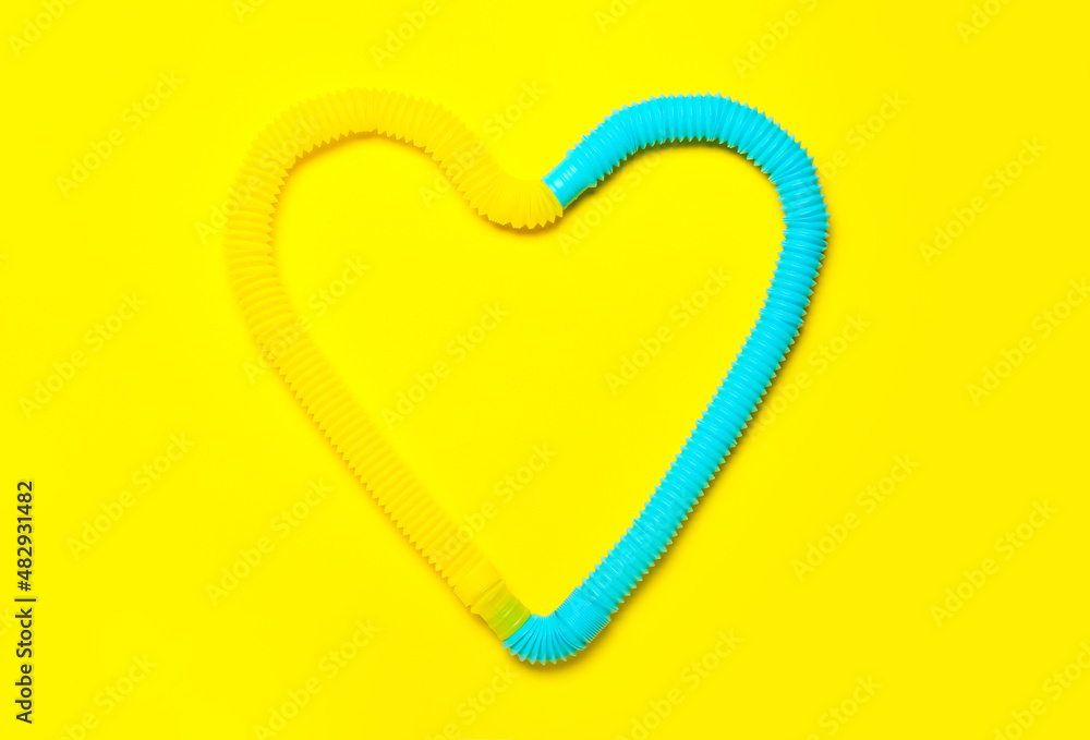 黄色背景的Pop Tubes制成的心形