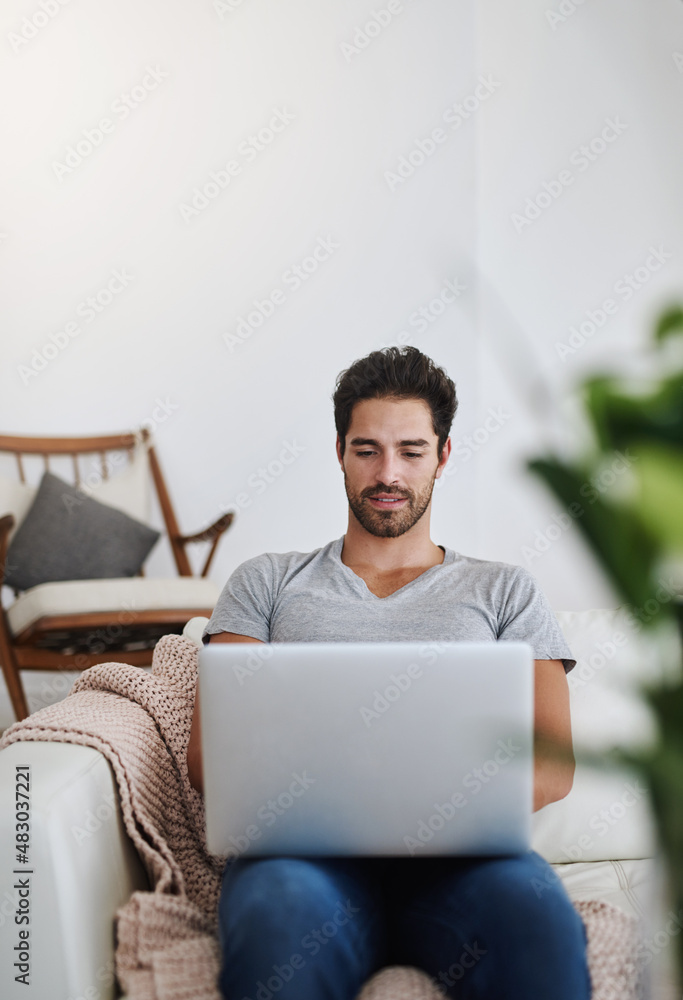 Logging into his personal email account. Shot of a young man browsing the internet at home on a lapt